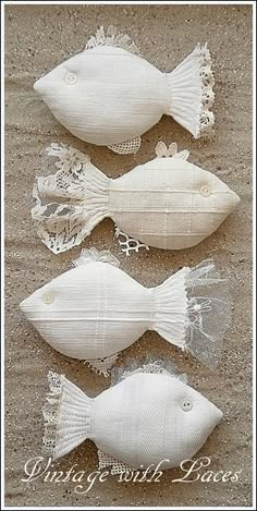 three white fish made out of fabric and lace