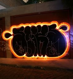 a neon sign that has been drawn on to the side of a building with graffiti written all over it