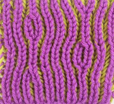 a close up of a purple and yellow knitted object