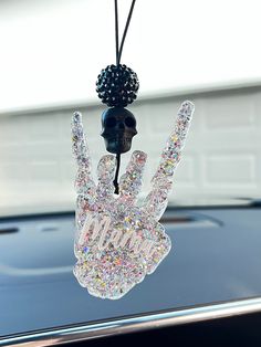 a crystal hand hanging from the hood of a car