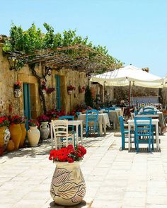 an outdoor dining area with tables, chairs and umbrellas