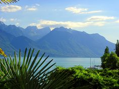 the mountains are in the distance and there is a boat out on the water