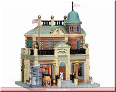 a toy model of a building with a flag on the roof and an american flag flying above it