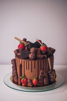 a chocolate cake topped with strawberries and chocolate covered cookies