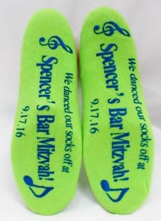 two green socks with blue writing on them