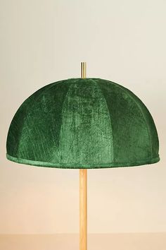 a green lamp shade on a wooden stick