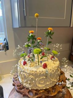 a cake decorated with flowers and fruit on a table