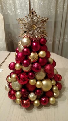 a red and gold christmas tree on a table