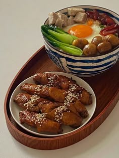 two plates of food on a tray with chopsticks and an egg in the middle