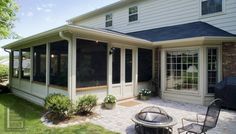 a patio with a fire pit in the middle and an enclosed back yard behind it