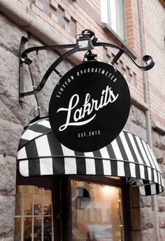 a black and white striped awning on the side of a building with a sign that says lakrit's