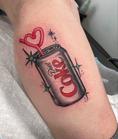 a tattoo on the arm of a woman with a can of coke and scissors in it