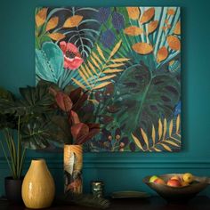 a painting hangs on the wall next to two vases with fruit and plants in them