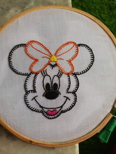 a close up of a embroidery on a piece of cloth with a mickey mouse face