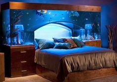 a bed room with a neatly made bed and an aquarium