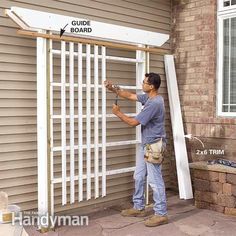 a man is working on a white door outside the house that's being built