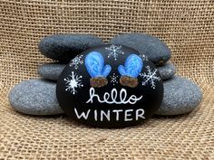 a rock painted with the words hello winter on it