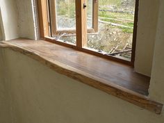 an empty window sill in the corner of a room that is being renovated with wood trim