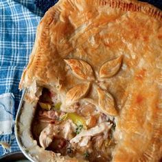 a chicken pot pie next to peas on a blue towel