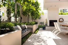 an outdoor living area with white furniture and trees