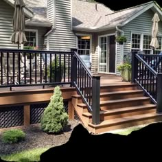 a deck with black railing and steps leading up to the front door is shown in this image