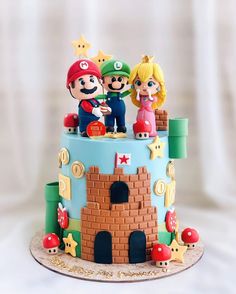 a birthday cake with mario and princess peaches on the top is made out of fondant