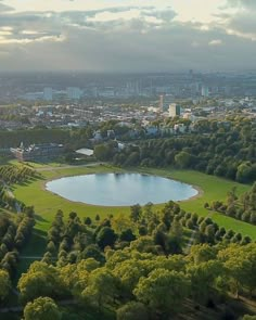 an aerial view of a park with a lake in the middle and trees surrounding it