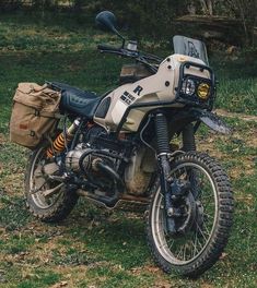 a dirt bike parked on top of a lush green field next to a wooded area