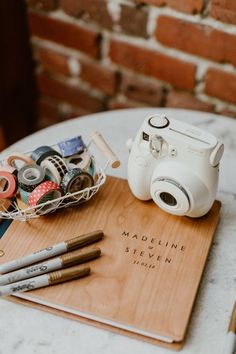 a camera and some pens sitting on top of a table