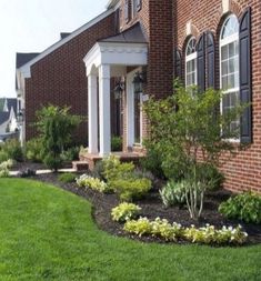 a front yard with flowers and trees in it