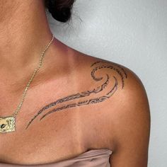 a woman with a tattoo on her chest is wearing a pink dress and gold necklace