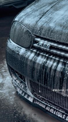 the front end of a car covered in snow