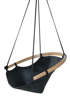 a black leather swing chair hanging from a wooden frame with two straps on each side