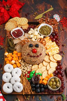 a platter filled with cheeses, crackers and other snacks on top of a wooden table