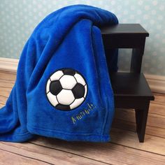 a blue towel with a soccer ball on it sitting next to a small wooden table