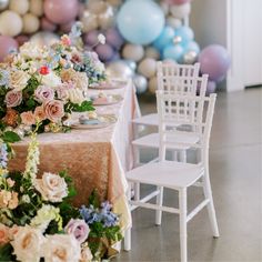 the table is set with flowers and balloons