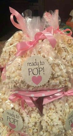 two bags filled with popcorn sitting on top of a counter next to another bag that says ready to pop