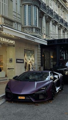 a purple sports car parked in front of a building next to another black car on the street