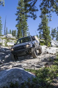 a jeep driving through the rocks on a trail