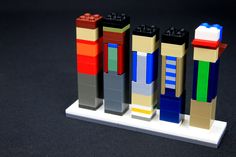 three legos are arranged in the shape of different colored blocks on a white stand