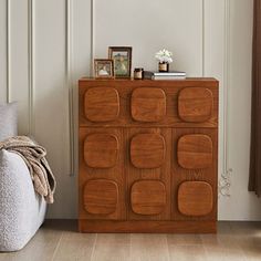 a wooden cabinet sitting next to a white couch