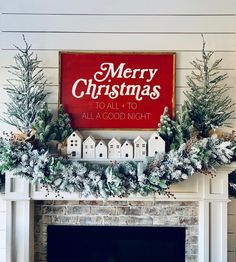 a christmas mantel decorated with greenery, pine cones and red sign that says merry christmas