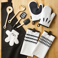 kitchen utensils are laid out on a table with black and white aprons