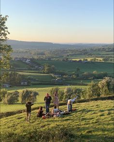 some people are standing in the grass on a hill with a dog and two other people