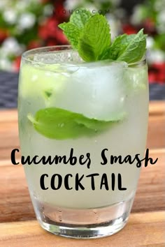 a close up of a drink in a glass on a table with the words cucumber smash cocktail