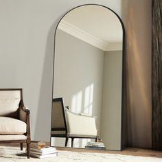 a mirror sitting on top of a wooden floor next to a chair