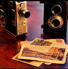 an old fashioned camera sitting on top of a wooden table next to some paper towels