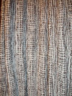 a close up view of the texture of a blanket on top of a wooden table