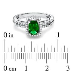 On her May birthday, dazzle her with a ring that's just her style! Crafted in fine sterling silver, this magnificent fashion ring features a glistening 7.0 x 5.0mm faceted cushion-cut, lab-created green emerald center stone that grabs the eye. Framing the emerald and lining the double shank, shimmering white sapphires are the just-right finishing touch. Custom made to fit her ring size. Sterling silver rings cannot be resized after purchase. Classic Emerald Ring With Halo Design, 14k White Gold Halo Jewelry For Anniversary, 14k White Gold Halo Design Jewelry For Anniversary, Sterling Silver Ring With Halo Design, Classic Halo Ring With Brilliant Cut For May Birthstone, Fine Jewelry Emerald Ring With Vs Clarity For Promise, Dazzling Emerald Ring With Diamond Accents As Gift, Classic Diamond Halo Ring For May Birthstone, Dazzling Emerald Ring With Halo Setting For Promise