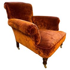 an orange velvet chair with wooden legs and foot rests on a white background, it appears to be in the process of reupholving